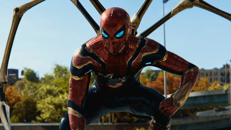 Spider-Man, wearing the Iron Spider armor, crouching on a car in Spider-Man: No Way Home