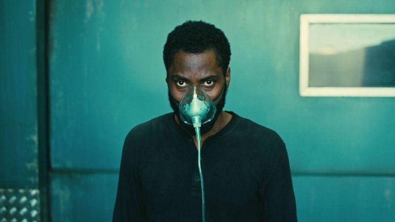 John David Washington as The Protagonist in Tenet, wearing an oxygen mask and looking off behind the camera.