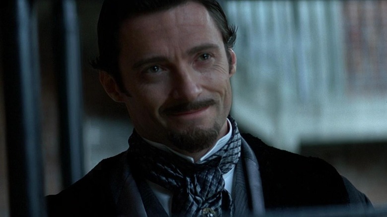 Hugh Jackman as Robert "The Great Danton" Angier, softly smiling while looking out of frame in The Prestige.