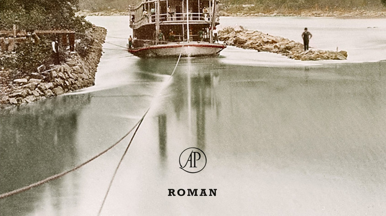 A man stands next to a steamboat on the river on the cover of Suttree