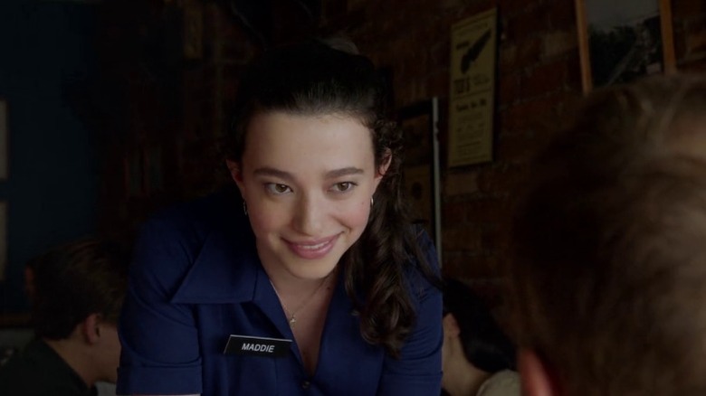 Mikey Madison as young Maddie Jonson smiling whilel wearing a waitress uniform and nametag on Imposters