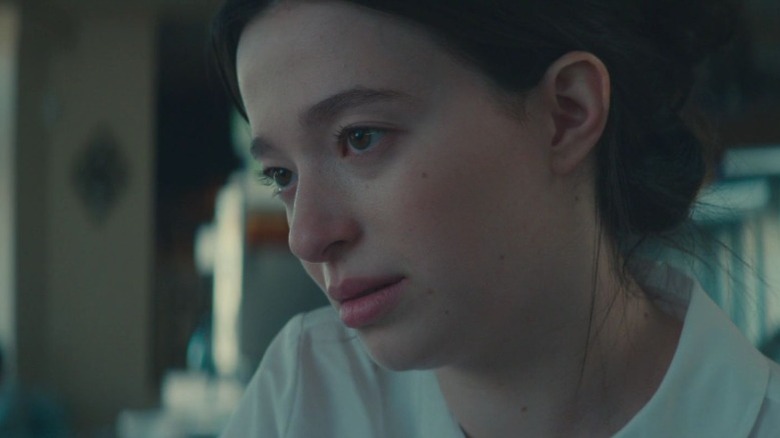 Mikey Madison as Kathleen sitting and staring with a pensive expression in Nostalgia