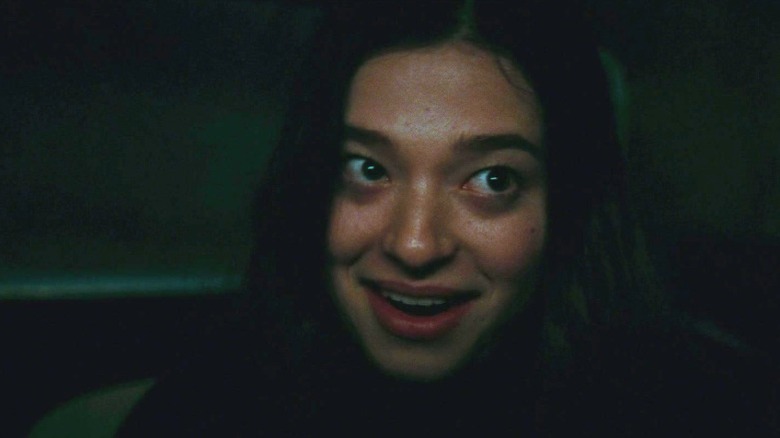Mikey Madison as Sadie talking and smiling maniacally in the backseat of a car in Once Upon a Time in Hollywood