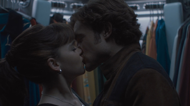 Han (Alden Ehrenreich) and Qi'ra (Emilia Clarke) kissing in coat closet in Solo