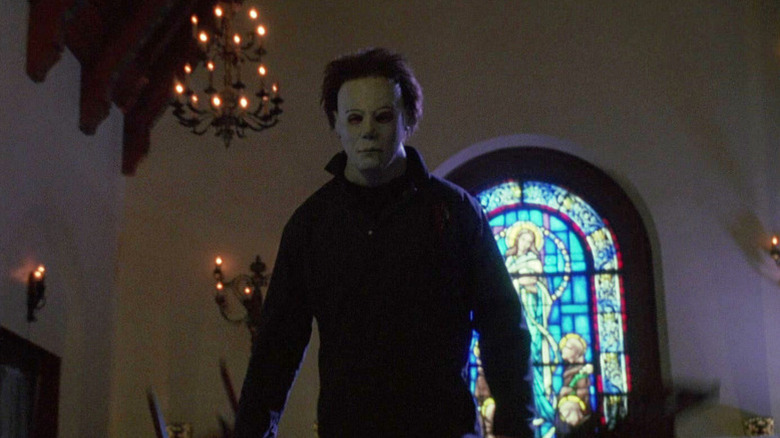 Michael Myers (Chris Durand) stands in a hall in front of a stained glass window in Halloween H20: 20 Years Later