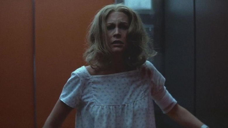 A disheveled Laurie Strode (Jamie Lee Curtis) stands in front of an elevator in Halloween II (1981)
