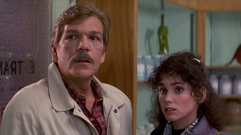 Dan Challis (Tom Atkins) and Ellie Grimbridge (Stacey Nelkin) stand in a storeroom in Halloween III: Season of the Witch