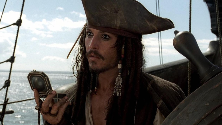 Johnny Depp as Captain Jack Sparrow checks his compass in Pirates of the Caribbean: The Curse of the Black Pearl