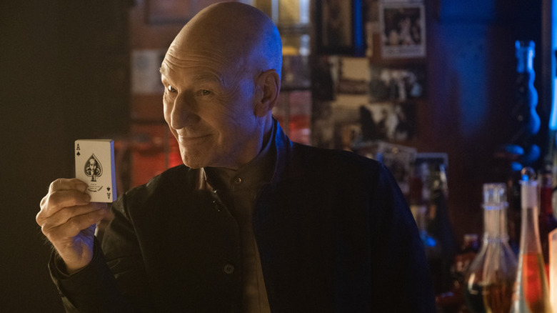 Jean-Luc Picard (Patrick Stewart) smiles while holding a deck of cards in Star Trek: Picard