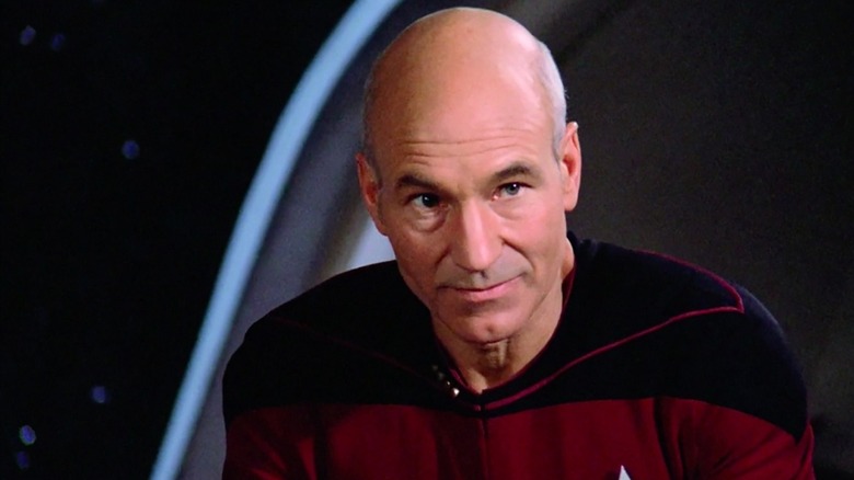 Jean-Luc Picard (Patrick Stewart) glances up smiling slightly in Star Trek: The Next Generation