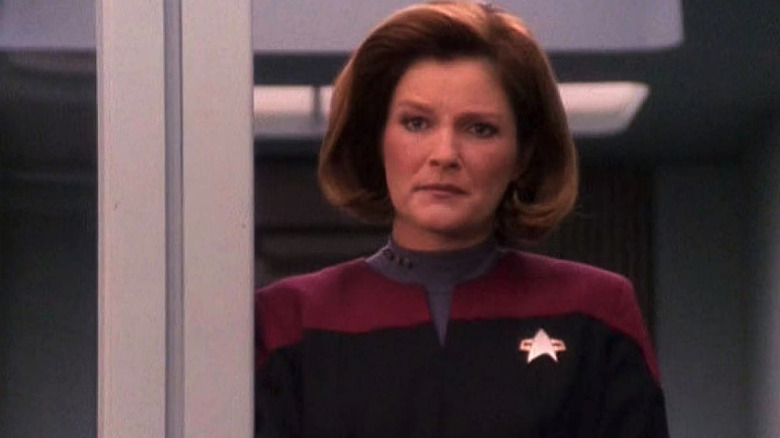 A dirtied Kathryn Janeway (Kate Mulgrew) stares sternly in Star Trek: Voyager