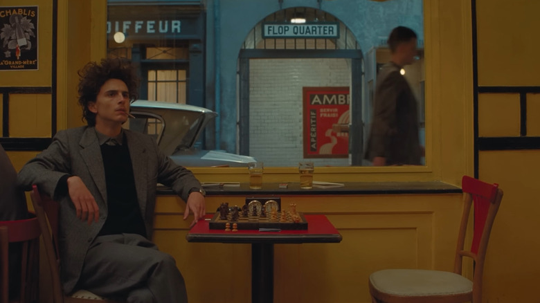 Timothée Chalamet as Zeffirelli, sitting alone and confused at a chess table in The French Dispatch