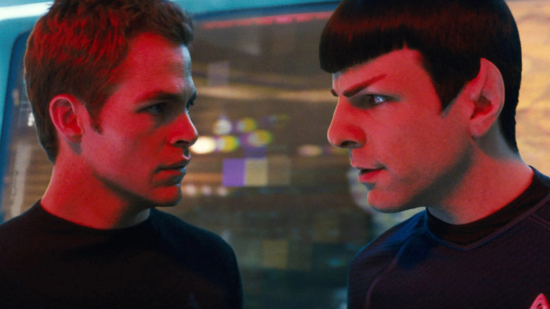 Jim Kirk (Chris Pine) and Spock (Zachary Quinto) look closely at each other under a red alert light in Star Trek (2009)