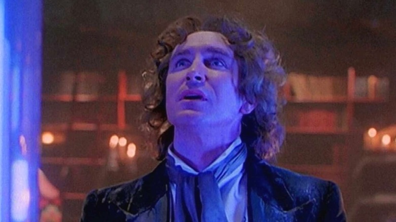 The Eighth Doctor (Paul McGann) looks up in the TARDIS bathed in blue light in Doctor Who (1996)
