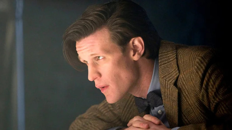 The Eleventh Doctor (Matt Smith) leans forward peering intently in Doctor Who
