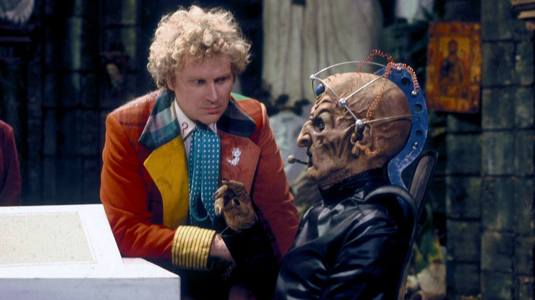 The Sixth Doctor (Colin Baker) interrogates an alien in Doctor Who