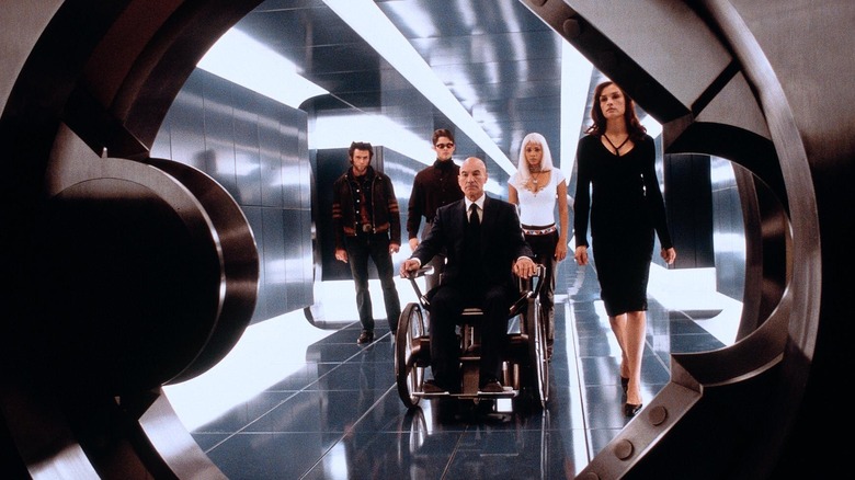 Hugh Jackman as Wolverine, Halle Berry as Storm, James Marsden as Cyclops, and Famke Janssen as Jean Grey walking with Patrick Stewart as Professor X into the X-Men base in X-Men