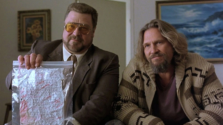 Jeff Bridges as Jeffrey "The Dude" Lebowski and John Goodman as Walter holding up a homework assignment in The Big Lebowski