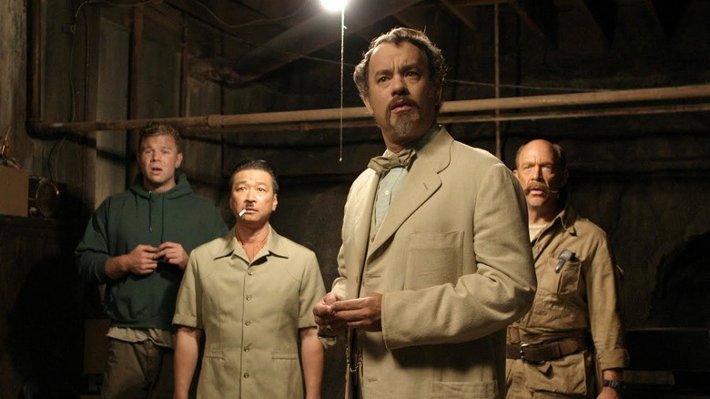 Ryan Hurst as Lump Hudson, Tzi Ma as "The General", Tom Hanks as Goldthwaite Higginson Dorr Ph.D, and J.K. Simmons as Garth Pancake, all standing in the basement in The Ladykillers