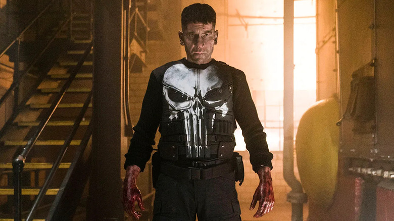 Jon Bernthal as Frank Castle, walking with bloody fists on The Punisher