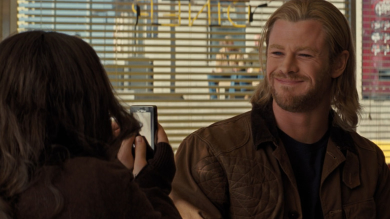 Darcy (Kat Dennings) takes picture of smiling Thor (Chris Hemsworth) in Thor
