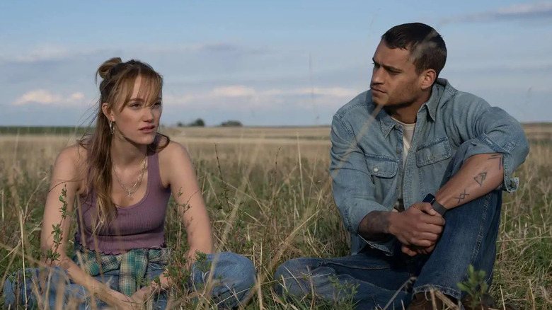 Kenna and Ledger sitting in a field talking in Reminders of Him