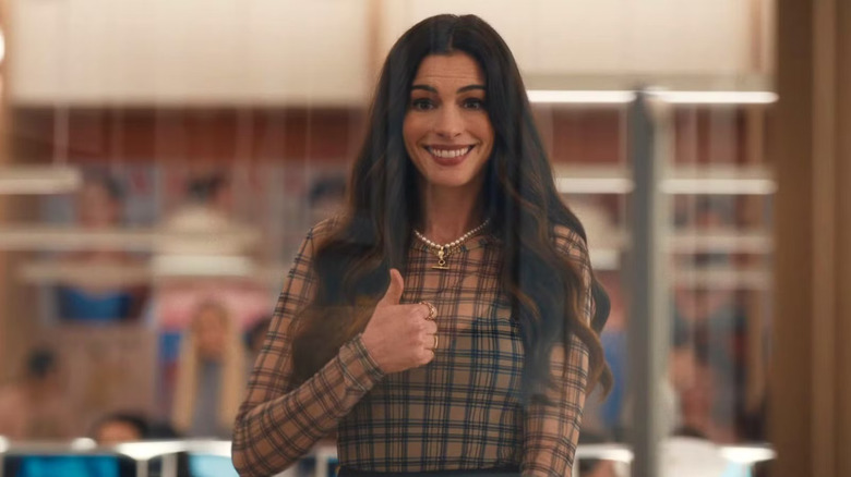 Andy behind a window giving a thumbs up and grinning in The Devil Wears Prada 2