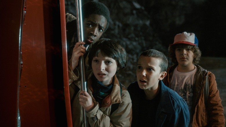 Lucas, Mike, Eleven, and Dustin looking scared in Stranger Things season 1