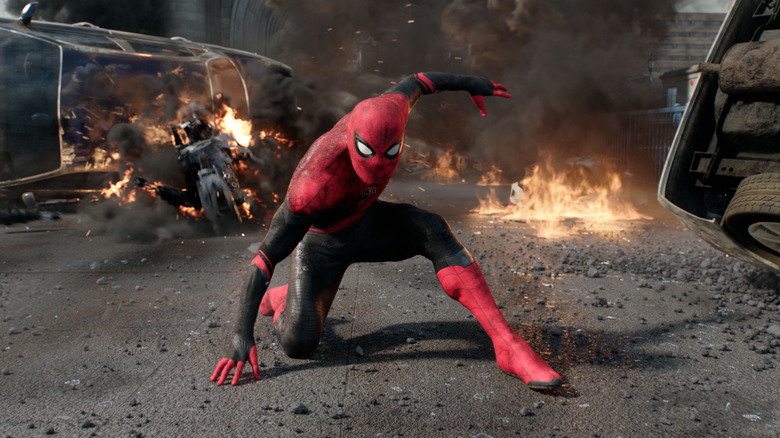 Spider-Man striking a three-point pose on a decimated city street in Spider-Man: Far From Home