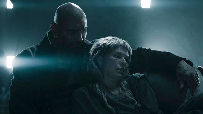 Gray Als (Milla Jovovich) rests against Boyce (Dave Bautista) in In the Lost Lands