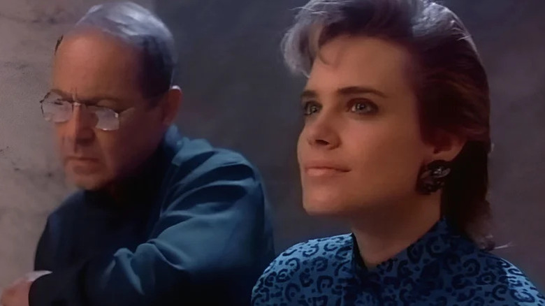 Michael D'Brannin (John Standing) and Miranda Dorlac (Catherine Mary Stewart) stand next to each other, with Miranda smiling, in Nightflyers (1987)