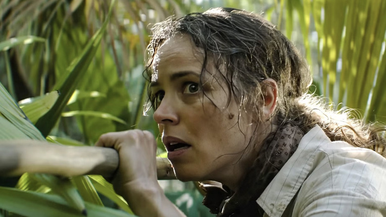 Rachel McAdams as Linda Liddle holding a stick in the woods while hunting a boar in Send Help
