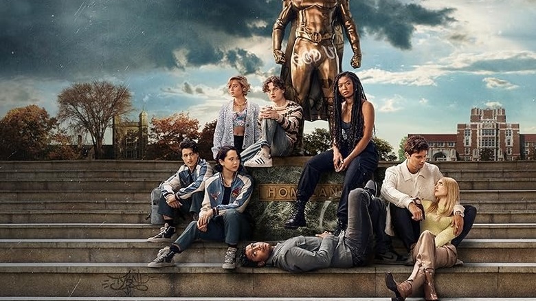Gen V season 1 poster - Jordan, Emma, Sam, Marie, Andre, Luke, and Cate sitting on steps beneath Homelander statue