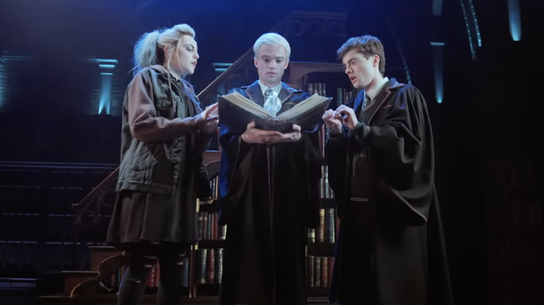 Delphi Scorpius and Albus reading a large book in Harry Potter and the Cursed Child