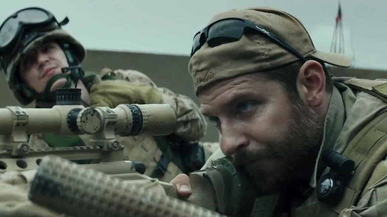 Chris Kyle (Bradley Cooper) aiming his rifle in American Sniper