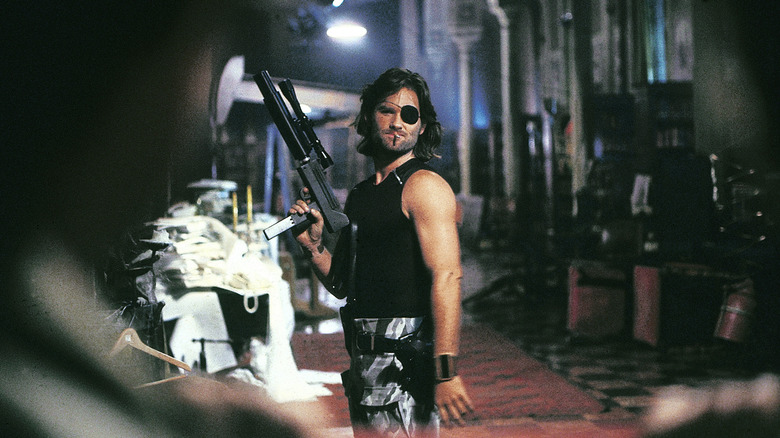 Snake Plissken standing in an alley with a gun in Escape from New York
