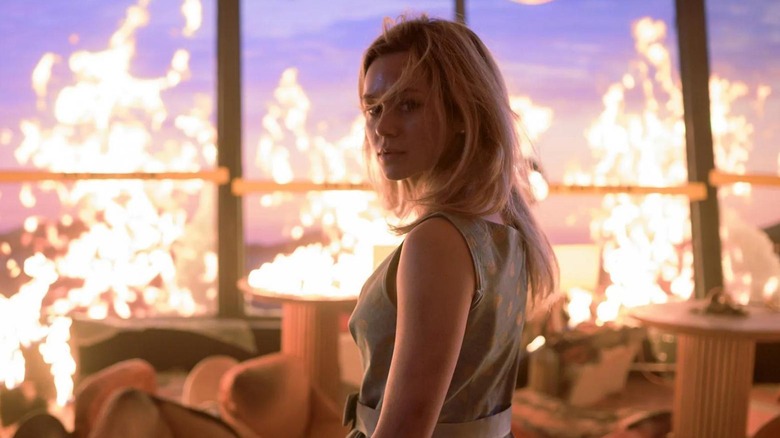 Brec Bassinger as Iris standing amongst the flames at the restaurant in Final Destination Bloodlines
