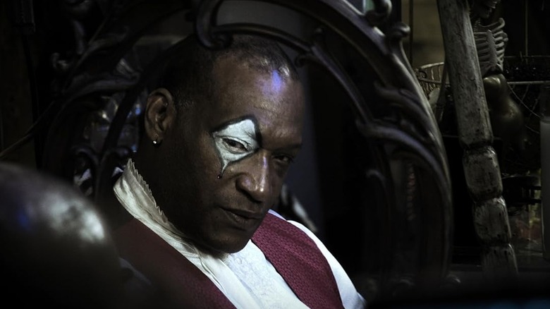 Tony Todd as Reverend Zombie sitting in his chair in Hatchet II