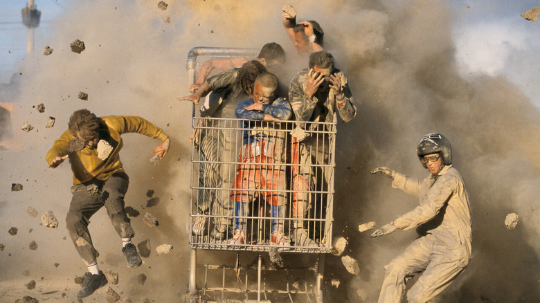 The cast riding in a giant cart as explosions go off in Jackass: The Movie