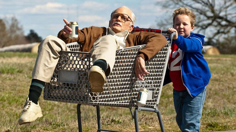 Johnny Knoxville as Irving drinking a beer in a shopping part being pushed by Jackson Nicoll as Billy in Jackass Presents: Bad Grandpa