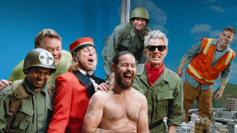 Jasper, Preston Lacy, Dave England, Poopies, Johnny Knoxville, and Steve-O gathered around Chris Pontius in the model city in Jackass Forever