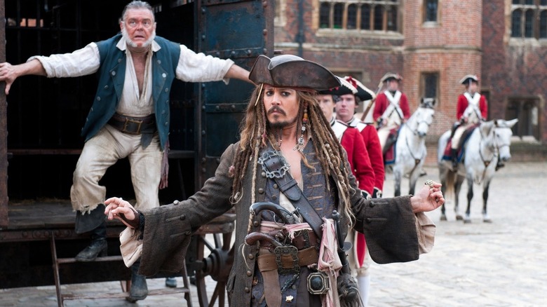 Johnny Depp as Jack Sparrow and Kevin McNally as Gibbs emerging from a wagon in Pirates of the Caribbean: On Stranger Tides
