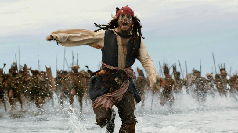 Johnny Depp as Jack Sparrow running away from tribespeople in Pirates of the Caribbean: Dead Man's Chest