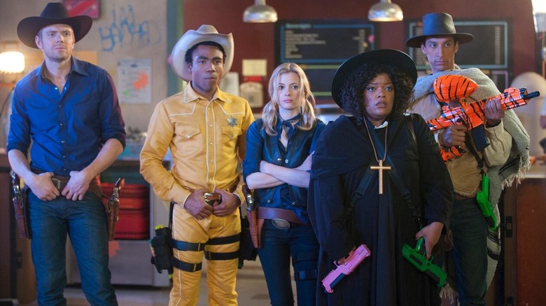 Jeff, Troy, Britta, Shirley, and Abed dressed in Western gear and holding paintball guns in Community