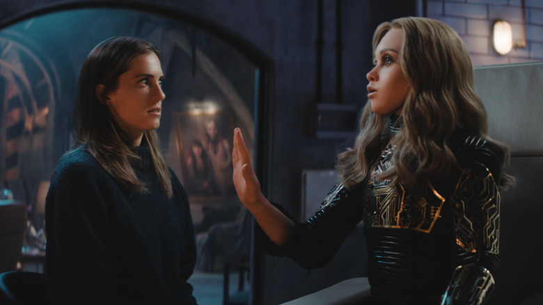 Allison Williams as Gemma with the new M3GAN raising her hand up in M3GAN 2.0