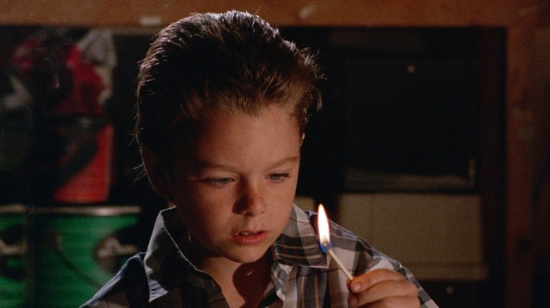 Little boy holding match in Mikey 