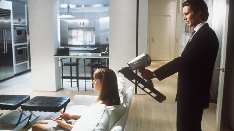 Patrick Bateman holds a nail gun up to the head of Jean in American Psycho