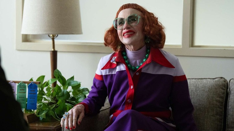 వెపన్స్‌లోని మార్కస్ కార్యాలయంలో నవ్వుతున్న గ్లాడీస్