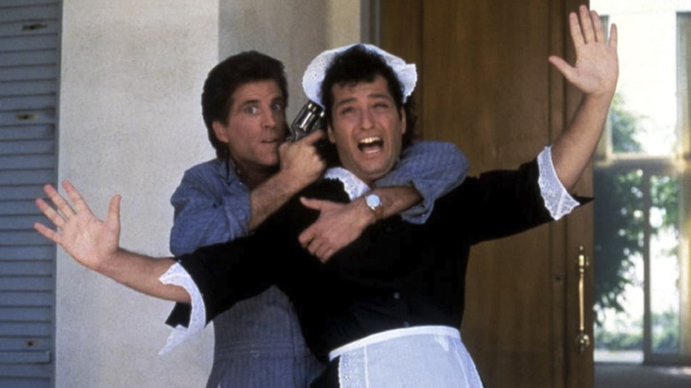 Ted Danson as Spence Holden holds a gun to the head of Howie Mandel as Dennis Powell in A Fine Mess