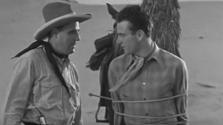John Waynen John Drury looks at Frank Hagney's Henry Simms / The Hawk when he is tied to the message Ride Hioboy